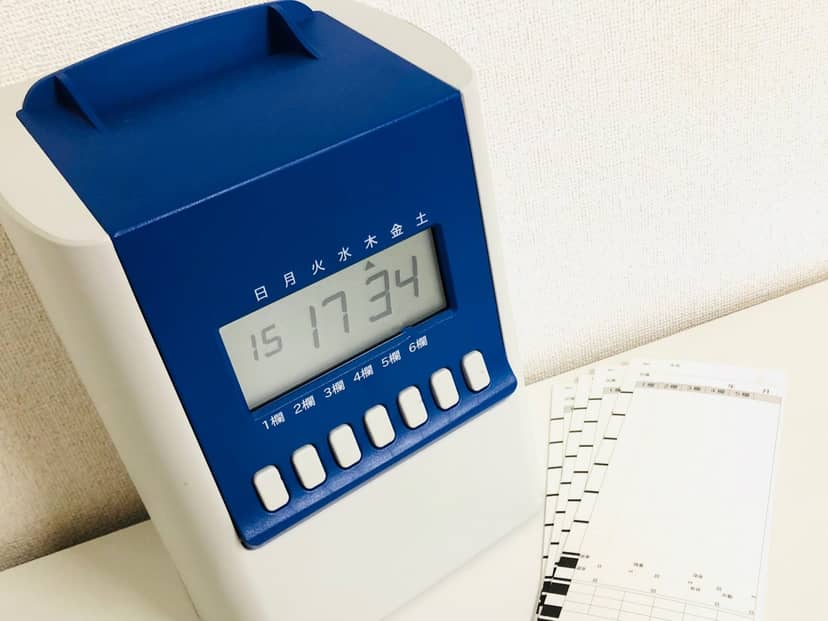 青いタイムレコーダーの表示は17時34分。横に未記入のタイムカードが4枚並んでいる（人物は写っていない）