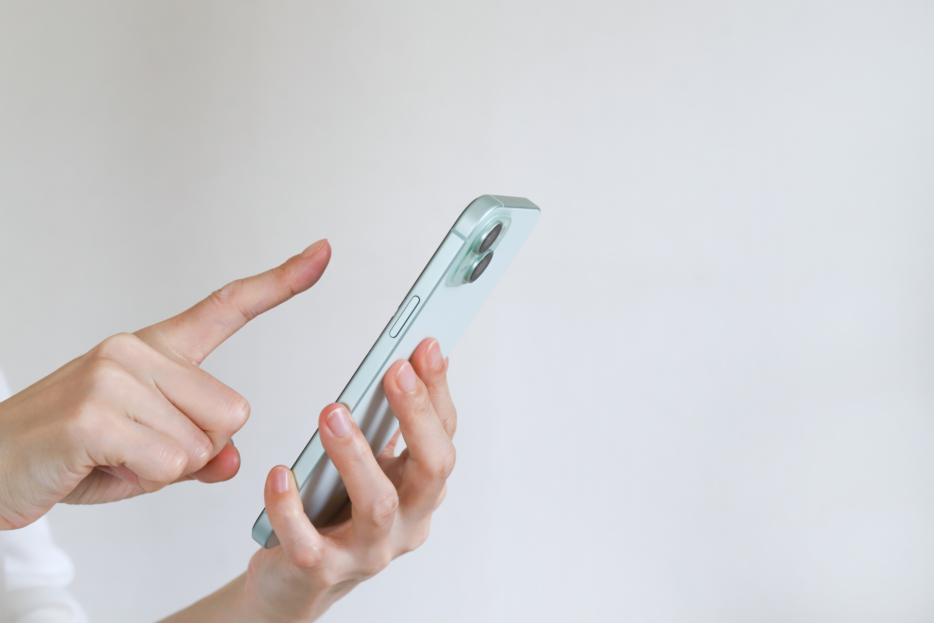 スマートフォンを指で操作する手元の写真
