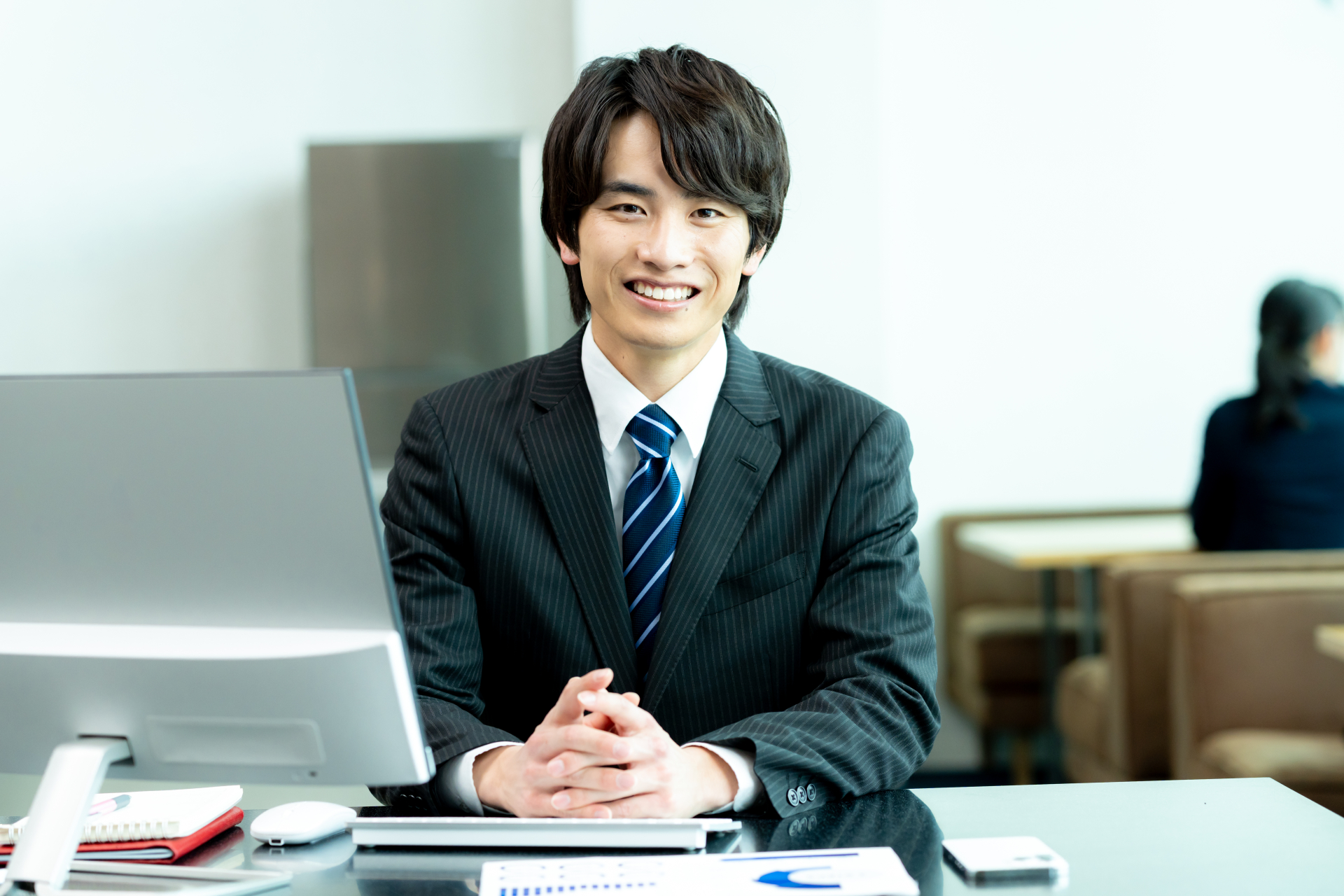 事務所の机でノートパソコンを前にしている社員の写真