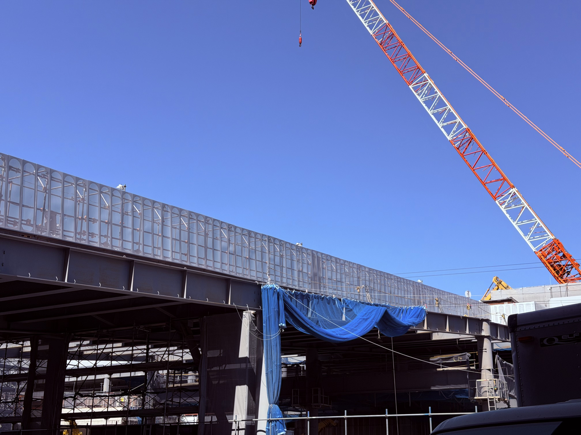 鉄骨の建方が進む建設現場とタワークレーンの写真